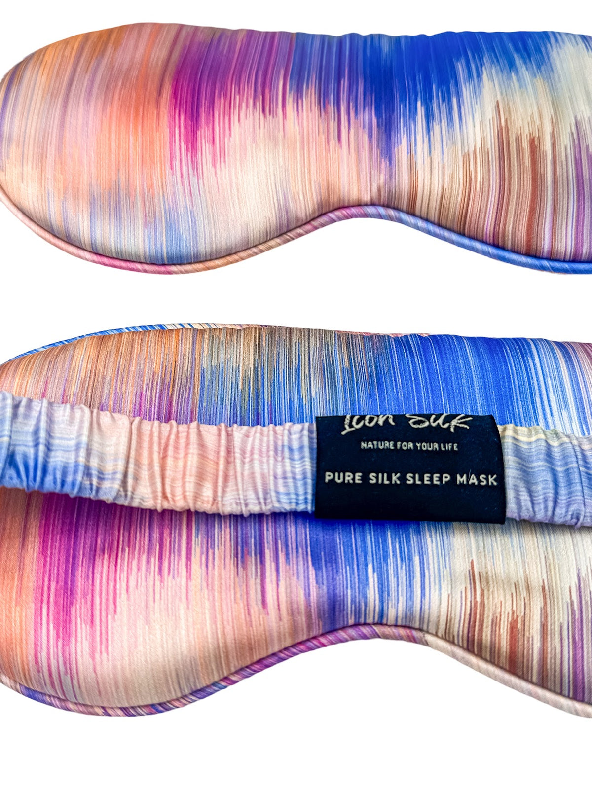 Detalle frontal y trasero del antifaz para dormir de seda morera con estampado efecto amanecer multicolor, banda elástica y etiqueta Icon Silk
