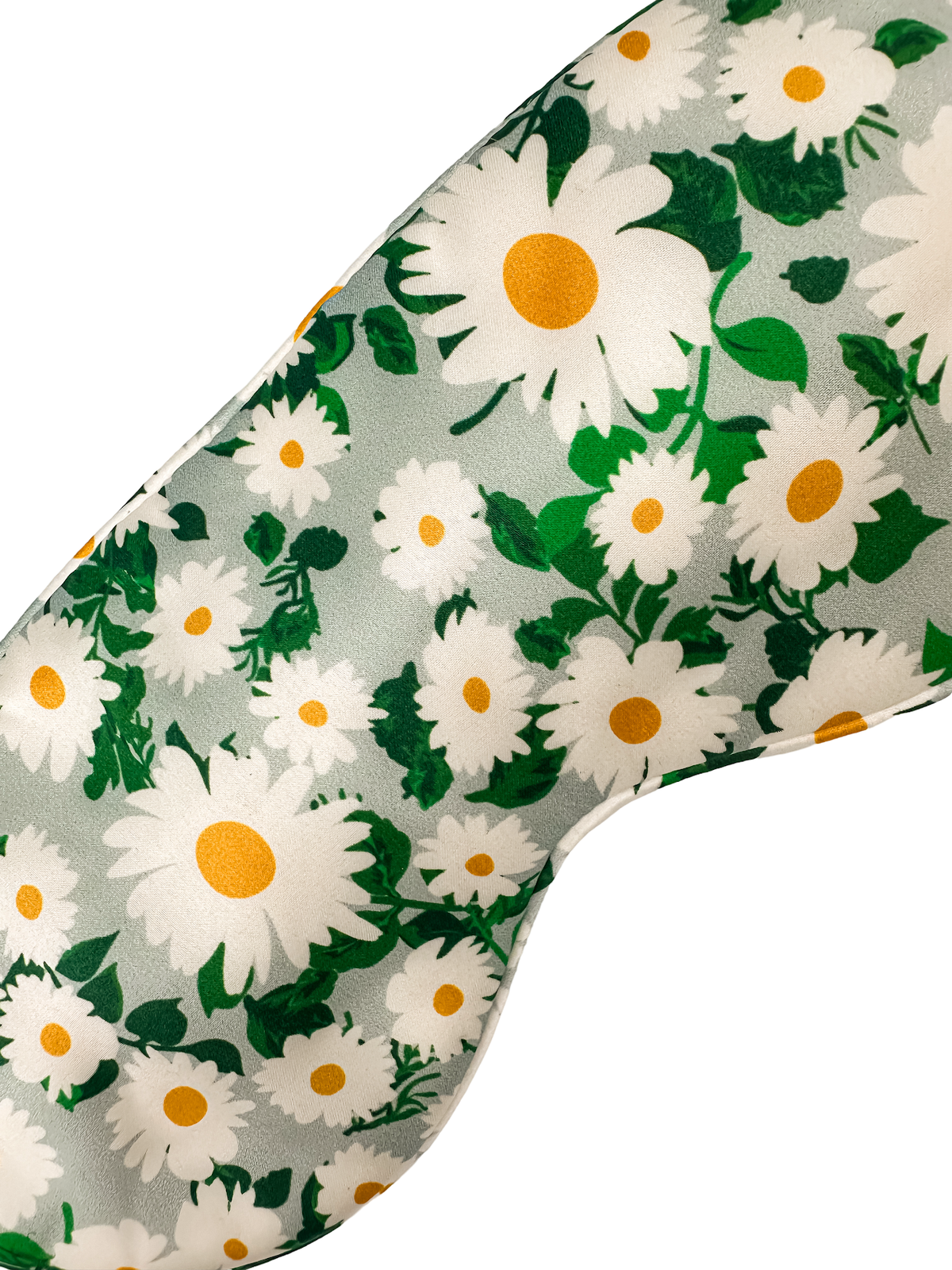Detalle del tejido de un antifaz de seda morera con estampado de margaritas blancas, centros amarillos y hojas verdes