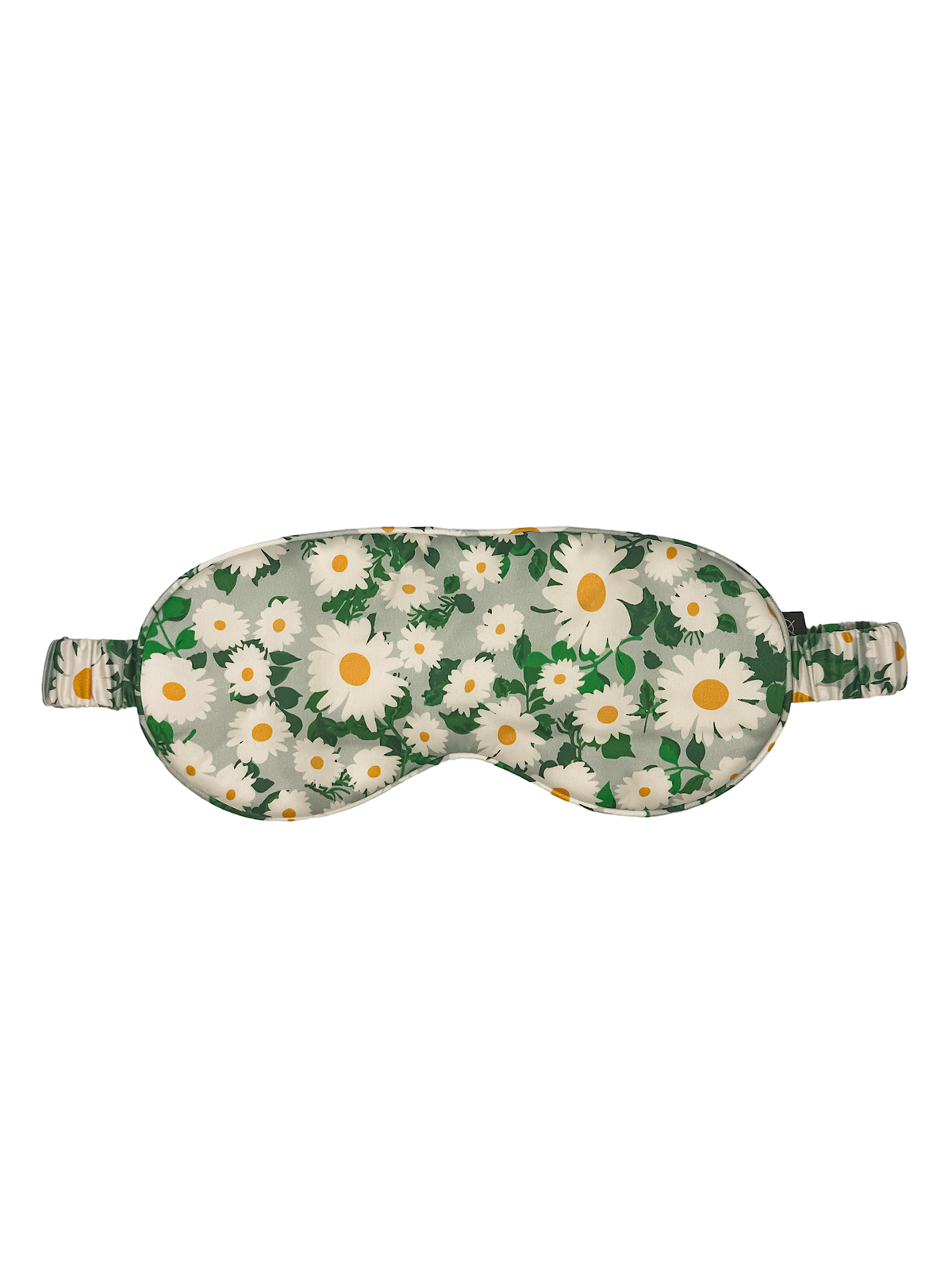 Antifaz para dormir de seda morera con estampado de margaritas blancas y hojas verdes visto de frente sobre fondo blanco