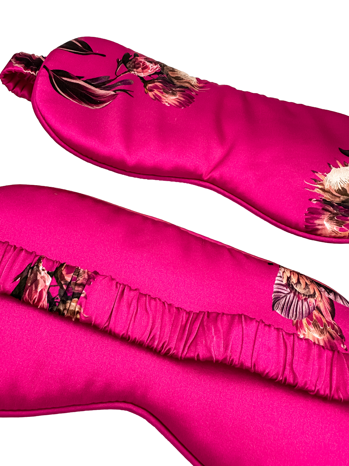 Detalle frontal y trasero de un antifaz para dormir de seda morera color fucsia con estampado floral y banda elástica