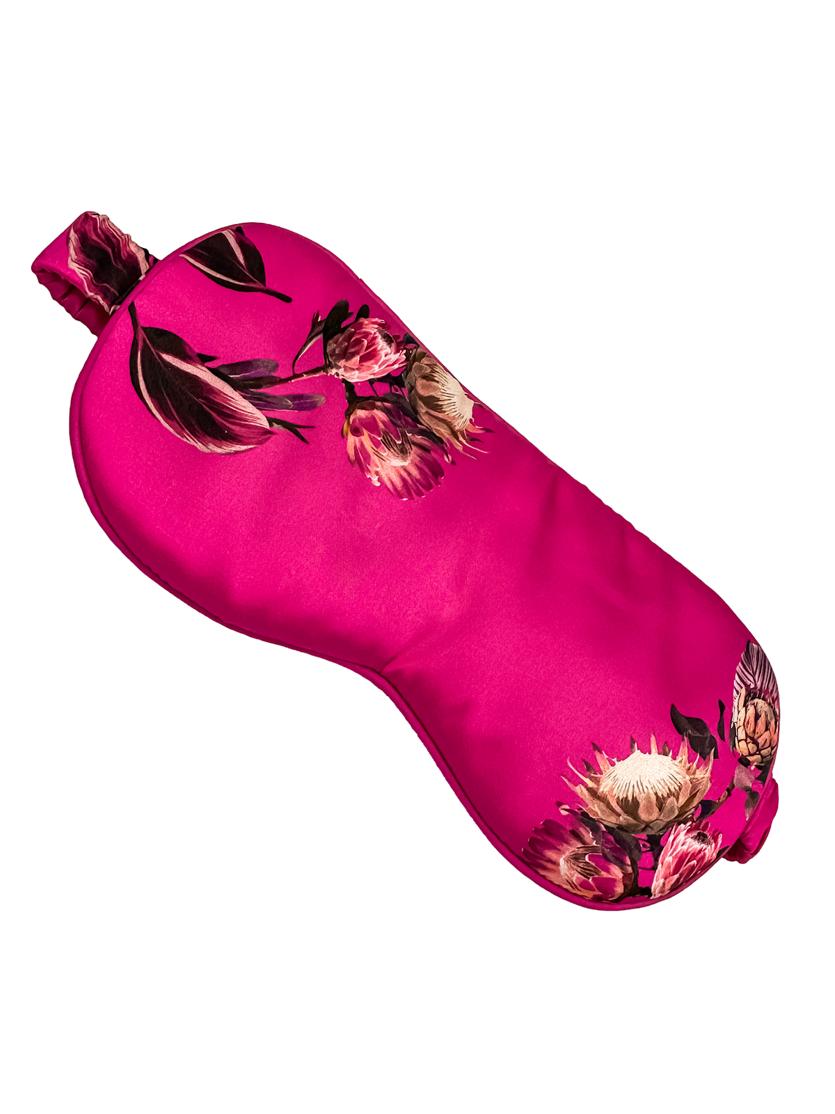 Antifaz para dormir de seda morera color fucsia con estampado floral visto en diagonal sobre fondo blanco