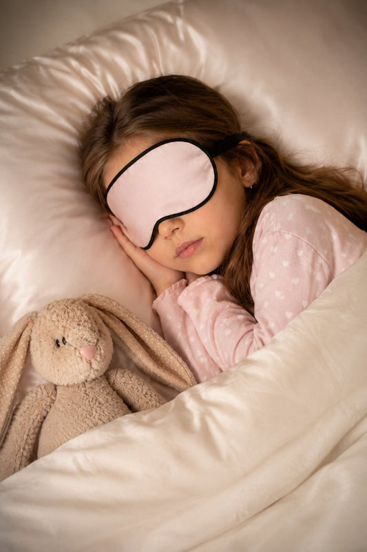Niña descansando con un antifaz de seda rosa de Icon Silk