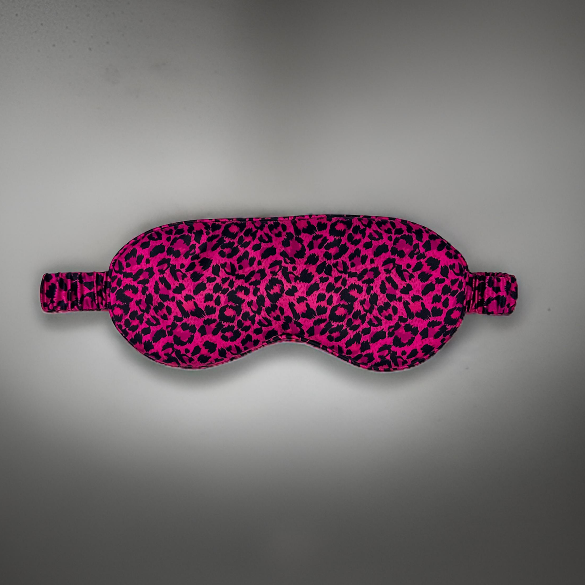 Antifaz para dormir de seda morera con estampado de leopardo rosa y negro, vista frontal 