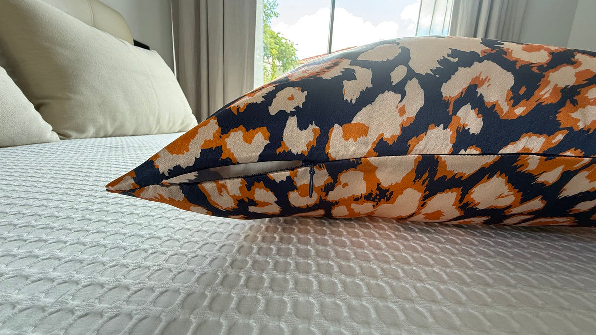 Detalle del cierre de cremallera de una funda de almohada de seda con estampado animal