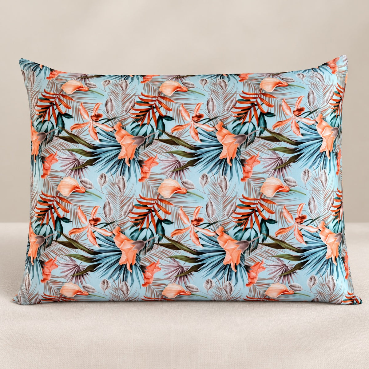 Funda de almohada de seda con estampado tropical sobre fondo neutro