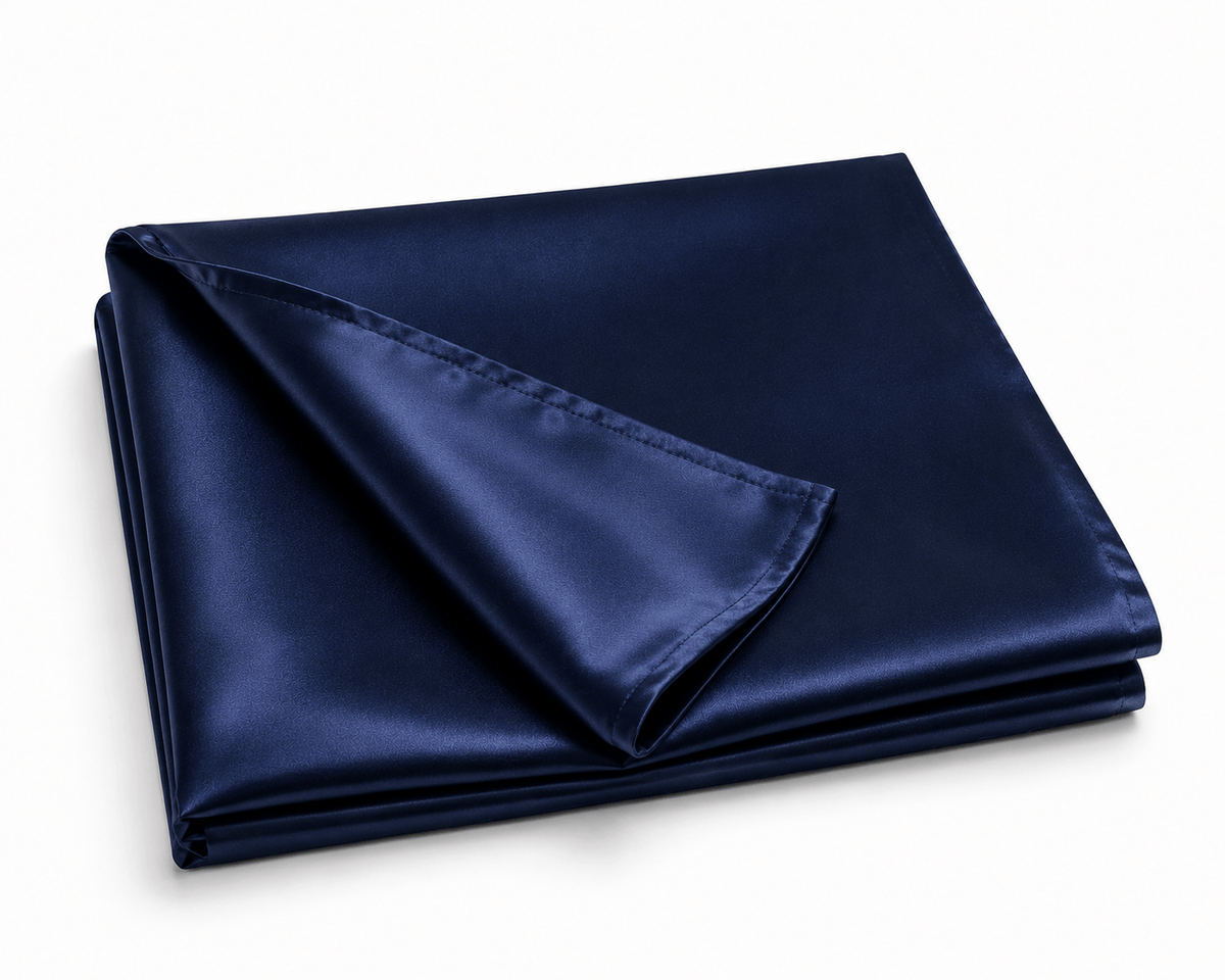 Funda de almohada de seda morera azul marino doblada con detalle del tejido y las costuras