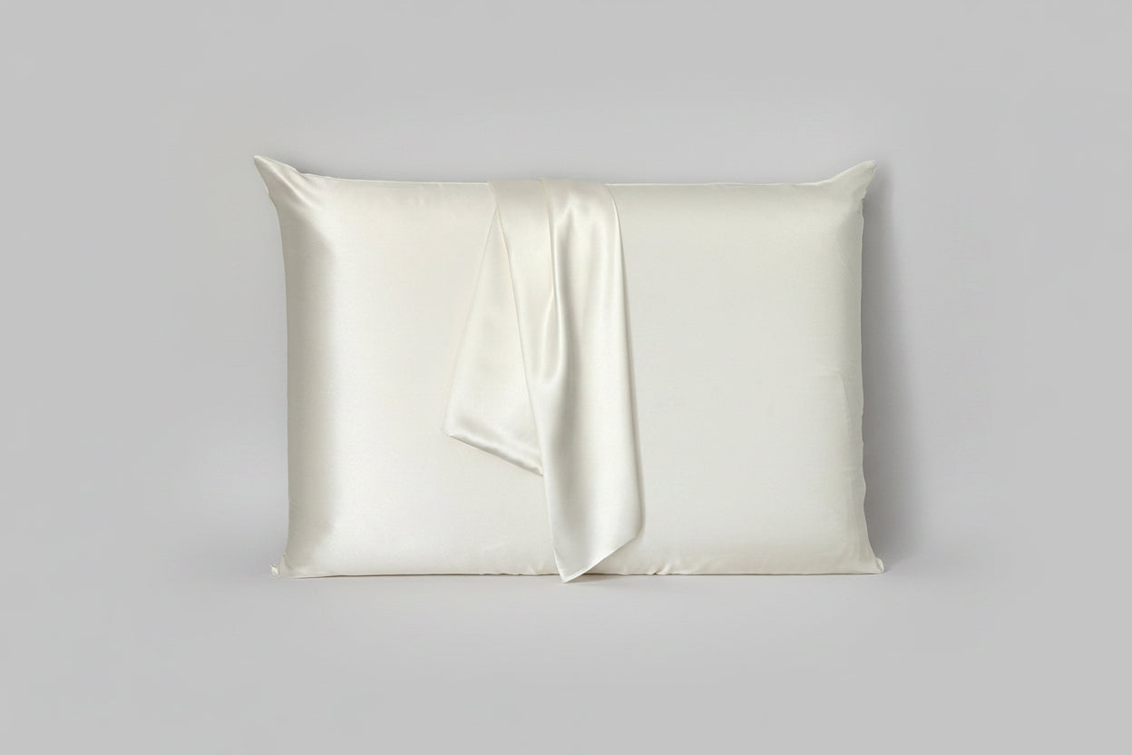 Funda de almohada de seda de morera color blanco sobre fondo gris claro