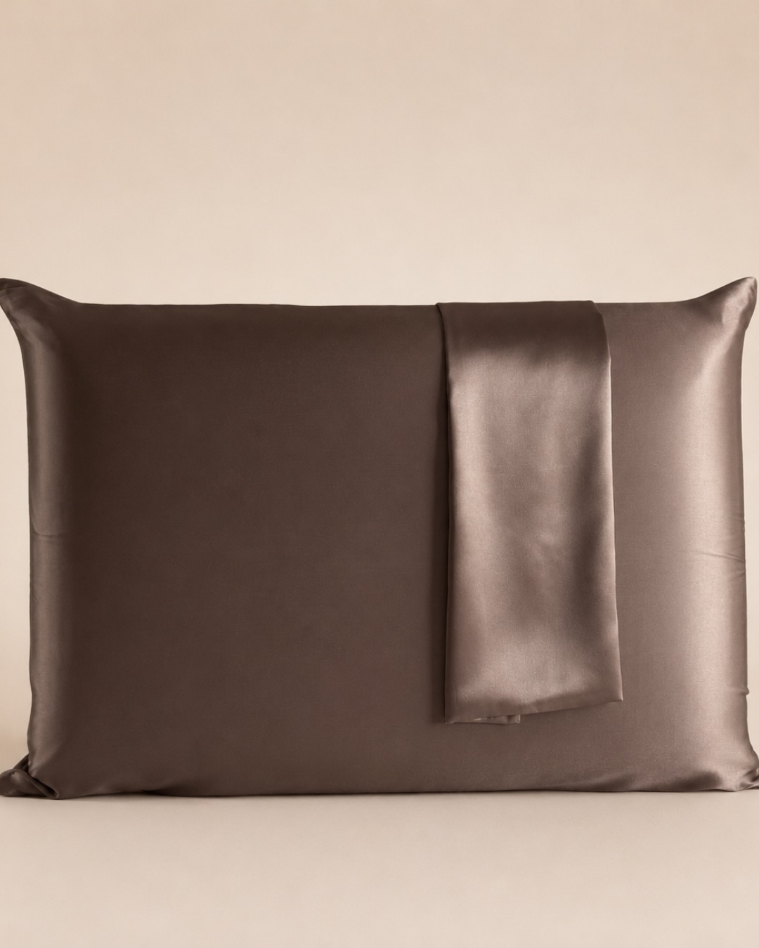 Funda de almohada de seda de morera color bronce sobre fondo beige