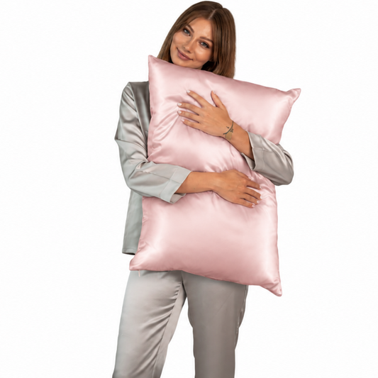 Mujer abrazando una almohada con funda de seda color flor de cerezo
