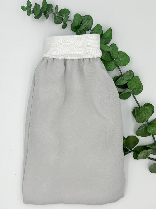Guante exfoliante de seda gris con puño blanco para el cuidado corporal